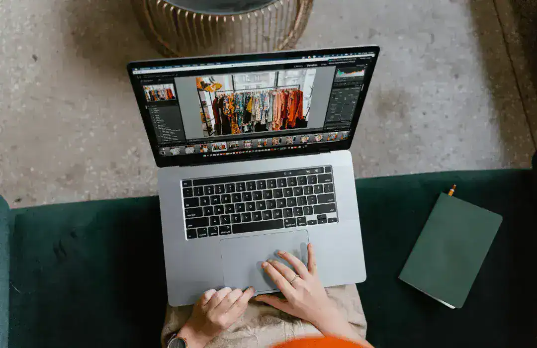 A top down view of a woman editing photos on her laptop
